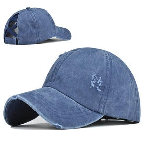Detail view of washed blue ponytail baseball cap featuring cross elastic back and distressed edges