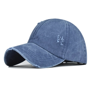 Detailed close-up of distressed washed denim baseball cap with vintage frayed accents