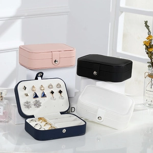 Stack of colorful mini jewelry boxes in leather with metal clasps and interior slots