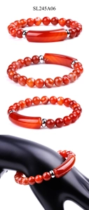 Macro detail of red agate beaded bracelet with curved stone bar and metal spacers