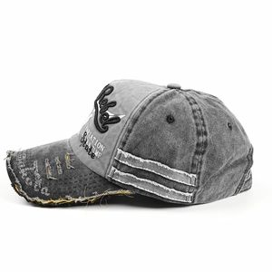 Close-up of distressed washed cotton baseball cap with Rebel embroidery and raw edge details