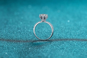 Detailed macro view of silver ring with six-prong moissanite setting and side diamonds