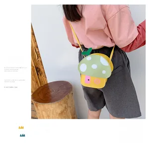 Detail of cute mushroom cross-body bag for kids with green dotted lid and leaf accent