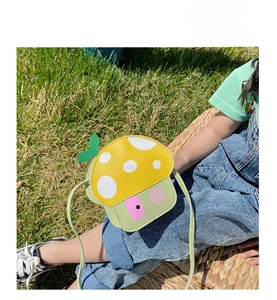 Detail of cute mushroom house shaped mini shoulder bag with polka dot roof and shoulder strap