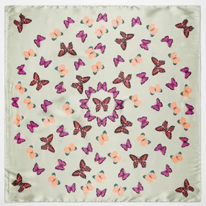 Detail view of square faux silk scarf featuring colorful butterfly prints on light green base