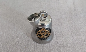 Detailed view of bell pendant with gold Celtic knot and black frosted texture