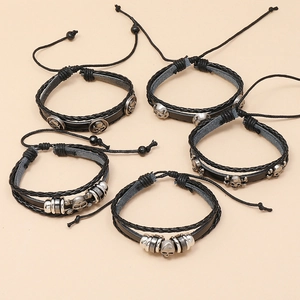 Detail of 5-piece punk leather bracelets with metal skull charms and braided ropes