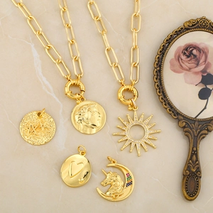 Collares de cadena dorada con colgantes vintage de moneda y unicornio en plano