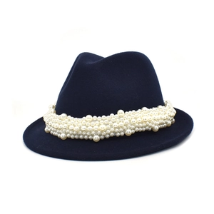 Detail of the elegant white pearl strand decoration on the navy blue wool fedora hat