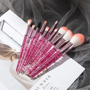 Detail of pink glitter liquid sand handles and soft pink-white gradient makeup brush bristles