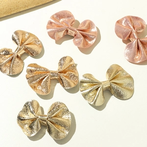 Detailed view of six gold and rose gold faux leather bow hair clips with metallic texture