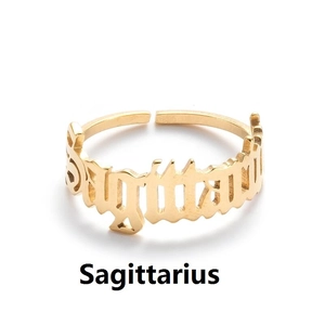 Macro shot of gold Sagittarius constellation lettering on a stainless steel open ring