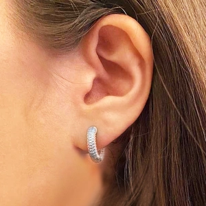 Classic silver hoop earrings with shimmering pavé zircon stones on a model