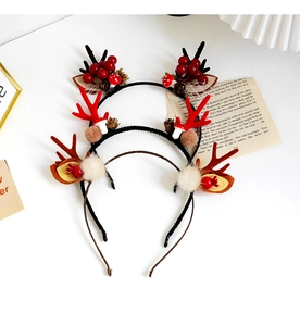 Detailed view of Christmas antler headbands with pine cones and berries on white background