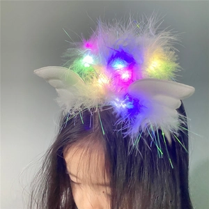Detail of LED light-up angel wing headband with white feathers and glowing colorful lights