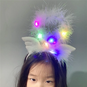 Close-up of LED glowing angel wing headband with white feathers and rainbow lights