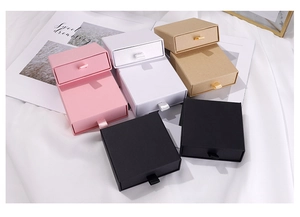 Detailed view of drawer-style jewelry gift boxes in pink, white, kraft and black colors