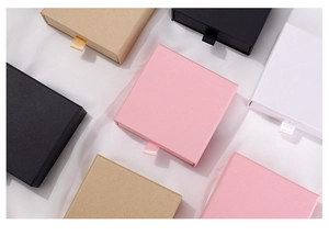 Detailed top view of drawer-style jewelry gift boxes in pink, black, white, and kraft paper