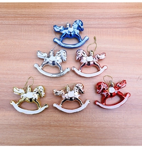 Set of six colorful metallic rocking horse ornaments on light wood background