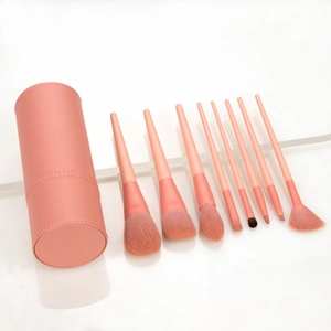 Pink 8-piece makeup brush set with leather storage tube on a white background