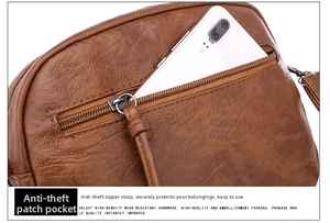 Détail d'un sac bandoulière vintage marron avec poche arrière zippée et un smartphone