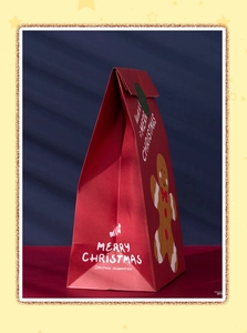 Detail of red Christmas paper gift bag featuring a gingerbread man and festive typography