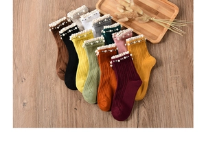Detail of ribbed knit cotton socks with lace ruffle trim and pearl beads in eleven colors