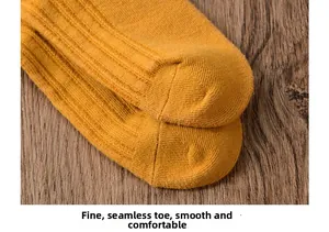 Detail of ginger yellow knitted socks with seamless toe and vertical ribbed texture