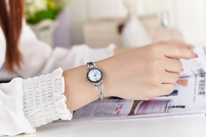 Detailed view of women's quartz watch with silver metal strap and crystal accents