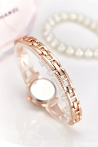 Detailed macro shot of rose gold metal watch strap with elegant chain link design