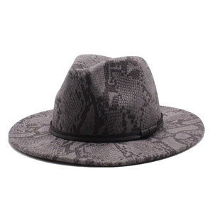 Detail view of wide brim fedora hat with grey snake print and black decorative leather band