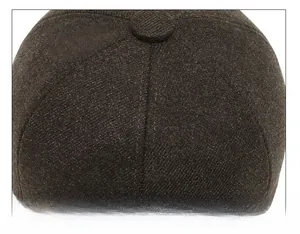 Macro shot of fine stitching and center button detail on dark brown winter baseball cap