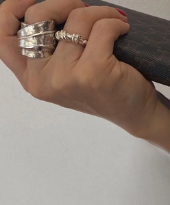 Detail view of wide sterling silver leaf ring and twisted band on hand for women