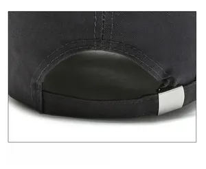 Détail de la boucle métallique réglable et du sergé de coton au dos de la casquette noire