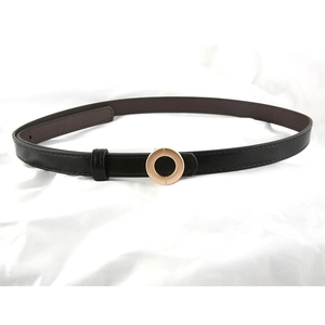 Minimalist black leather skinny belt with golden round buckle on white fabric