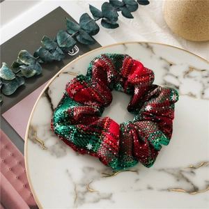Christmas hair scrunchie with red and green plaid patterns and white snowflake prints
