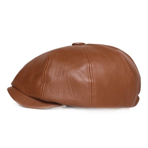 Detailed side view of a brown leather newsboy cap showing texture and stitching