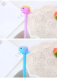 Close-up of cute cartoon dinosaur pen toppers in pink and blue silicone material