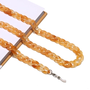 Amber acrylic glasses chain with metal clips and anti-slip loops on book background