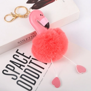 Detailed close-up of pink flamingo faux fur pompom keychain with golden metal clasp