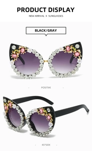 Detail view of black cat eye sunglasses with rhinestones and floral accents