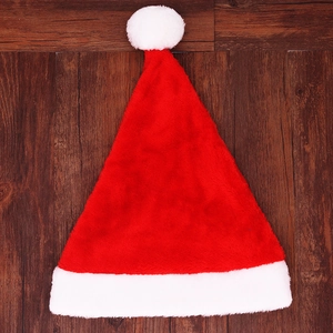 Detailed view of plush red and white Christmas hat on dark wood floor background
