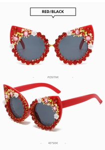 Detail view of red cat eye sunglasses with rhinestones, flowers and golden bees