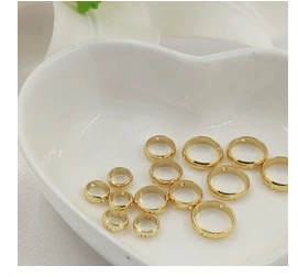 Close-up of 14K gold plated daisy pendants with cubic zirconia in a white ceramic dish