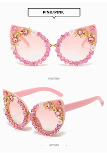 Macro shot of pink cat-eye sunglasses with rhinestone edges and flower bee details