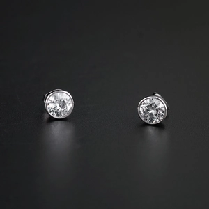 Vue macro de boucles d'oreilles en acier titane argenté avec zircons ronds clairs