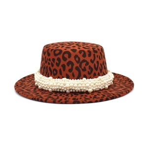 Detail of leopard print flat top wool hat with luxurious white pearl decorative band