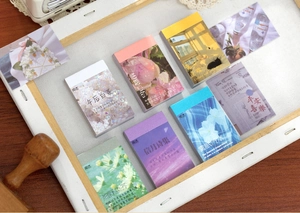 Artistic landscape sticker booklets collection for DIY journaling on dark wood surface