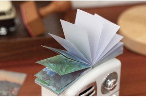 Close-up of decorative sticker book with landscape prints on a retro radio stand