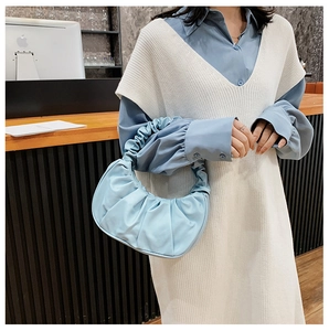 Detailed view of light blue ruched cloud bag with pleated texture and soft satin finish